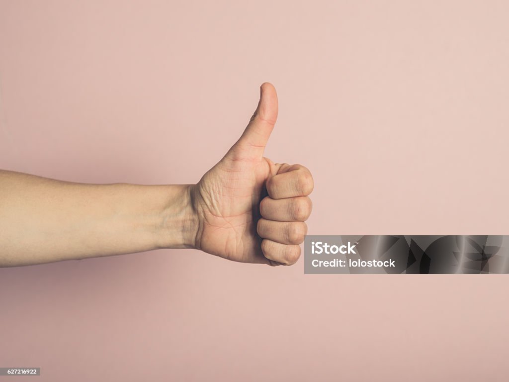 Female hand giving thumbs up A young female hand is showing thumbs up Thumbs Up Stock Photo