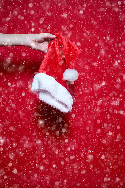 istock Womans hand holding a Santa Claus hat 627217026