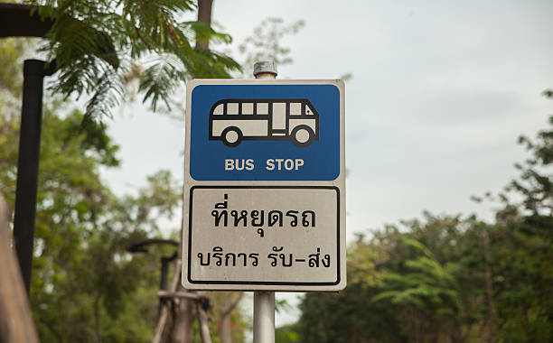 istock Bus stop sign on pole next to the road 627226014