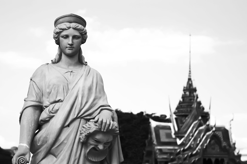 Two Different Culture : European sculpture with thai pavilion blur background. in Black and White.