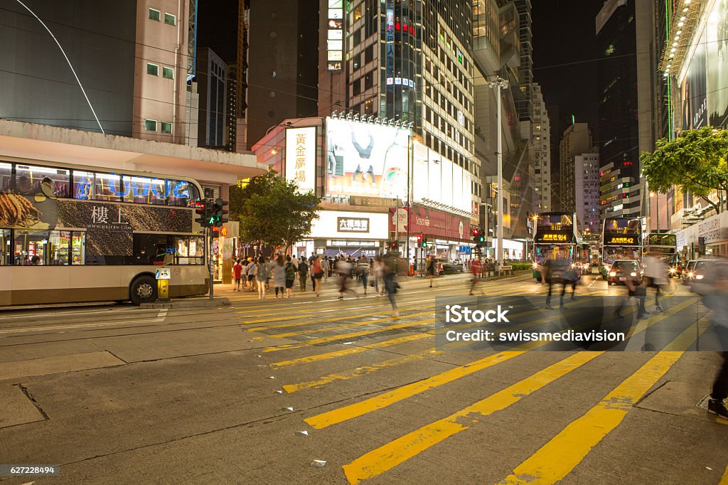 Blurred motion people crossing road on yellow zebra, Hong Kong Causeway Bay, Hong Kong, China: Blurred motion of a crowd of people crossing the road on the yellow zebra crossing. Causeway Bay is a popular shopping area in Hong Kong and one of the most densely populated areas in the world. Billboard Stock Photo