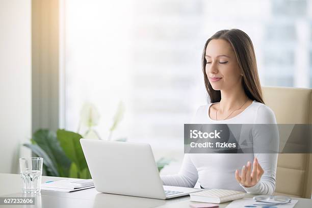 Young Woman Practicing Meditation At The Office Desk Stock Photo - Download Image Now