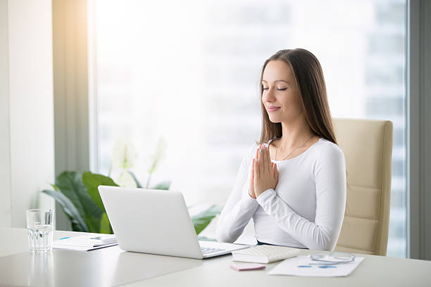 istock Young woman meditating near laptop 627232696