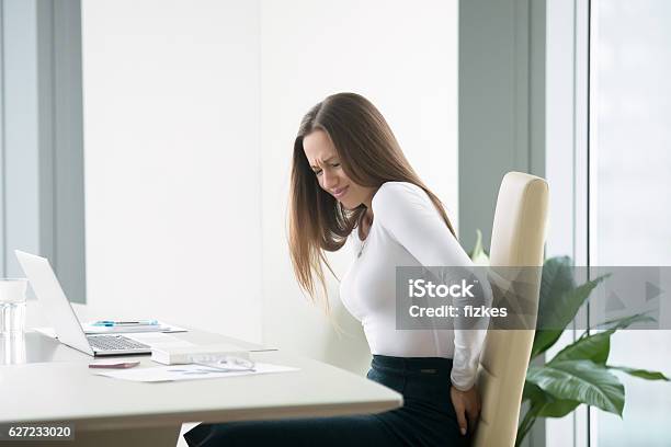 Young Businesswoman With A Backpain Stock Photo - Download Image Now - Hemorrhoid, Sitting, Pain