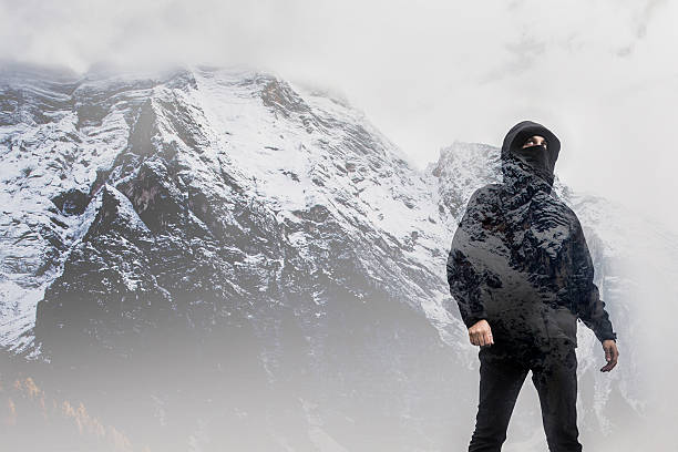 Man overexposed against snowy mountains.