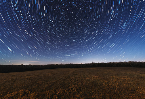 The stars spin above a vast Nova Scotian meadow.  Long exposure in Moonlight.