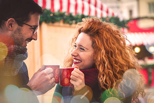 junges paar in der stadt während weihnachten trinken heißen kaffee - coffee couple italy drinking stock-fotos und bilder