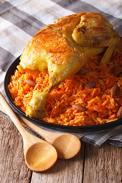 istock Kabsa - spicy rice with vegetables and chicken close-up. vertical 627249298