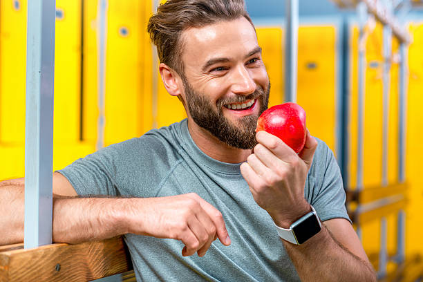 istock Man with apple in the gym 627250832