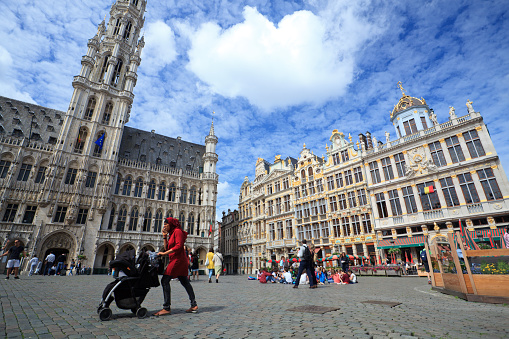 Brussels, Belgium - June 28, 2016: People of various cultures work and live and passing by the town hall on Grand Place in Brussels every day.