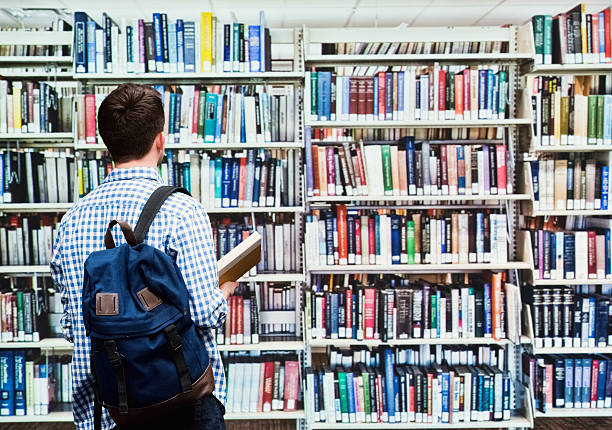 istock Rear view of student standing in library 627263728