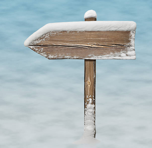 istock Wooden direction sign on snow background 627263928