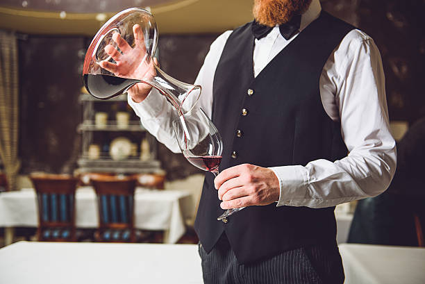 Man filling glass with red wine