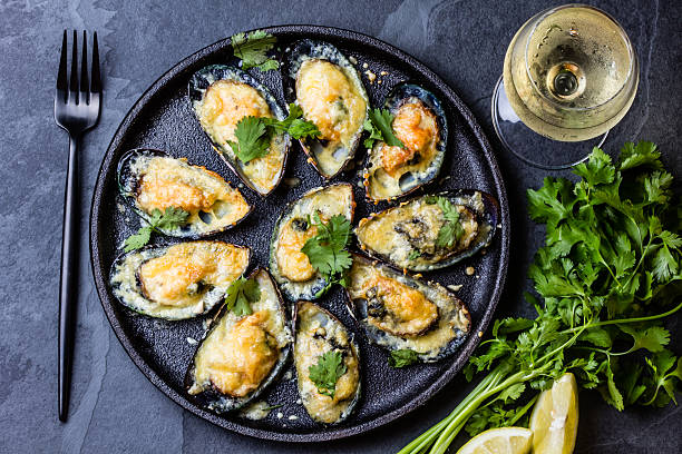 морепродукты. запеченные мидии с сыром и лимоном в скорлупе - prepared shellfish seafood crustacean mussel стоковые фото и изображения