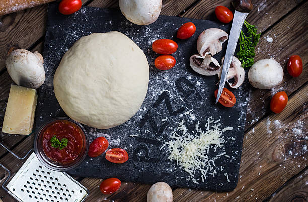 istock Pizza dough with ingredients on wood 627271750
