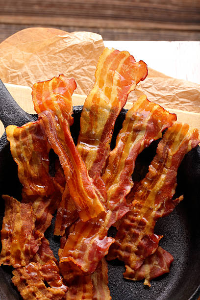 istock Hot fried bacon pieces in a cast iron skillet 627271792
