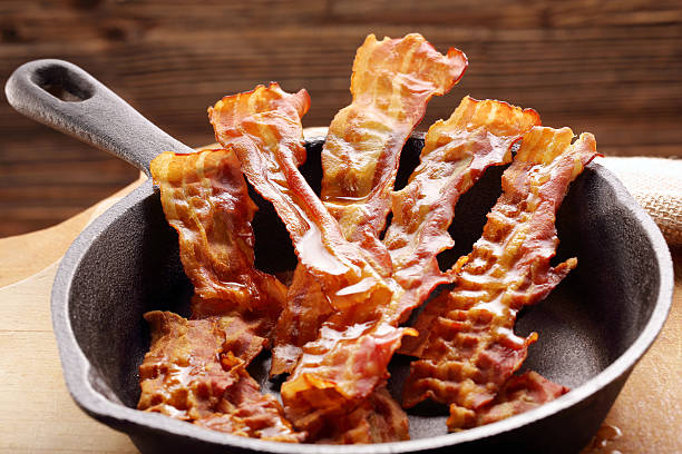 istock Hot fried bacon pieces in a cast iron skillet 627271836