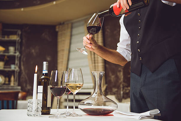 istock Waiter pouring scarlet wine into glass 627272324