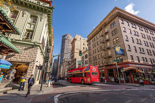 San Francisco, CA, USA - November 23, 2016:   San Francisco downtown street view. Residential and business buildings on the roadside. Incidental people on the background.Tourist bus in the middle of the street.