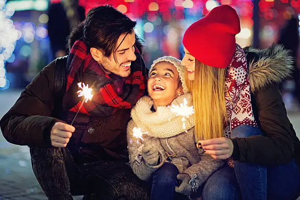 Photo of Young couple is hugging their daughter at Xmas