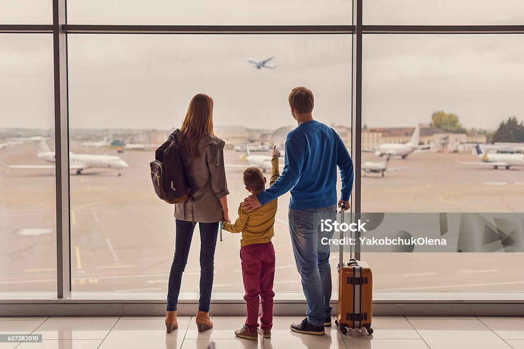Familie schaut aus dem Fenster am Flughafen - Lizenzfrei Familie Stock-Foto