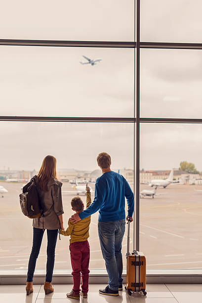 istock Family looking out window at airport 627282040
