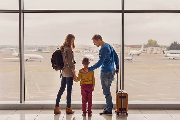 istock Family looking out window at airport 627282052