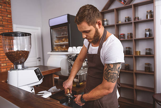 istock worker compressing grinds into the portafilter 627283910