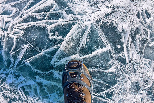 istock Human legs in hiking boot in ice crampons on texture 627290932