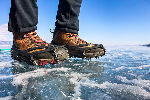 istock Human legs in hiking boot in ice crampons on texture 627290962