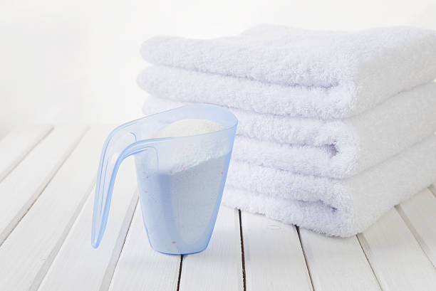 badetücher und waschpulver im messbecher - laundry detergent cleaning product concepts measuring cup stock-fotos und bilder