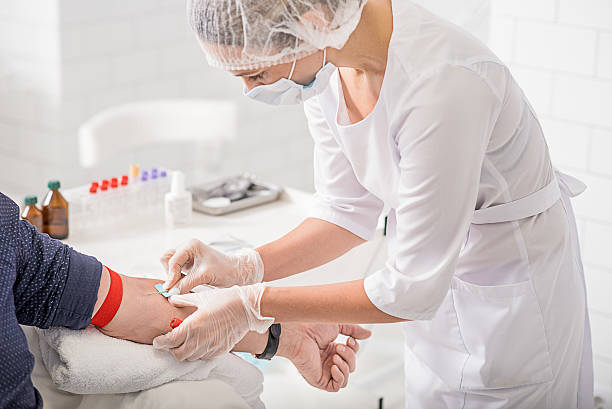 Skillful general practitioner testing male blood Concentrated doctor is doing blood collecting analysis for patient in hospital patient blood management stock pictures, royalty-free photos & images