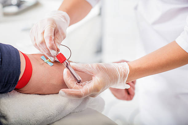 General practitioner doing blood test Close up of doctor hands taking blood from male vein into tube by catheter patient blood management stock pictures, royalty-free photos & images