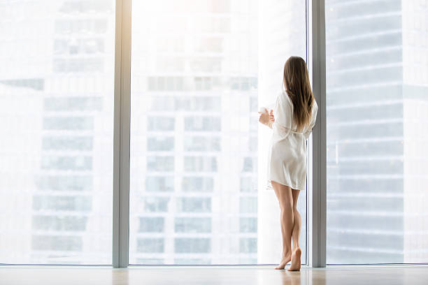istock Young woman near the floor window 627303628