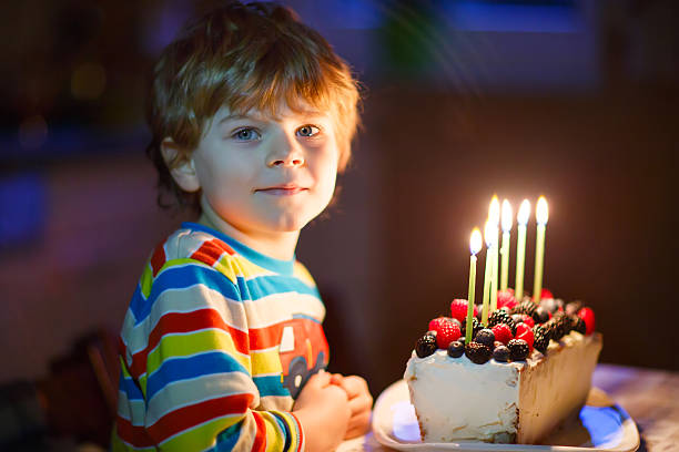 istock Little kid boy blowing candles on birthday cake 627304720