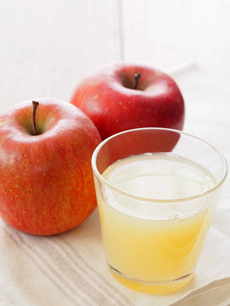 コップ1杯のアップルジュースや新鮮なレッドアップル添え - apple juice ストックフォトと画像