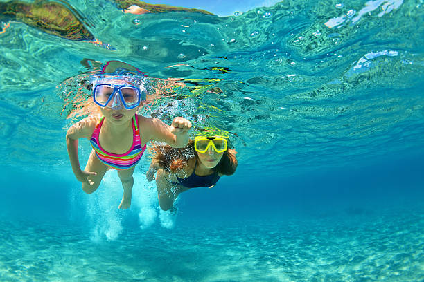 Mother with child swim underwater with fun in sea Happy family - mother with baby girl dive underwater with fun in sea pool. Healthy lifestyle, active parent, people water sport outdoor adventure, swimming lessons on beach summer holidays with child snorkeling photos stock pictures, royalty-free photos & images