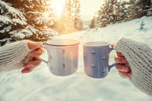 istock Couple hands with mugs with hot tea in winter forest 627317578