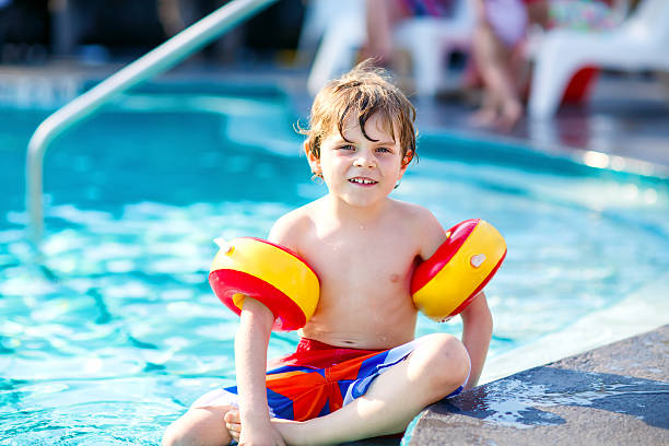 istock Happy little kid boy having fun in an swimming pool 627318568