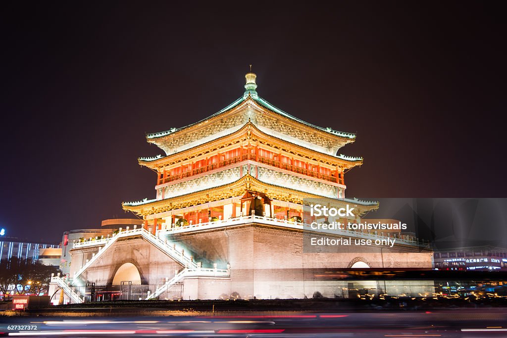 The  Xi'an Bell Tower illuminated at night Xi'an, China - December 5, 2015: The Bell Tower illuminated at night, with traffic trails in foreground Ancient Stock Photo
