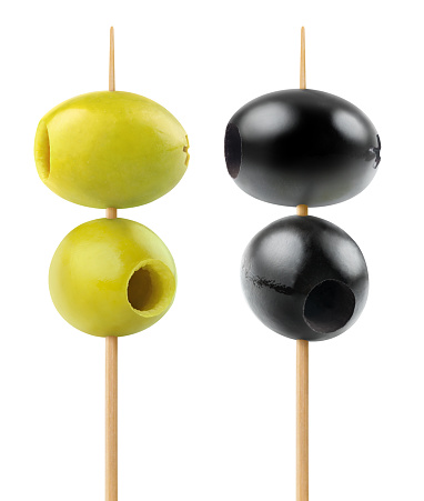 Isolated olives. Two green and two black pitted olive fruits on a wooden skewer isolated on white background with clipping path