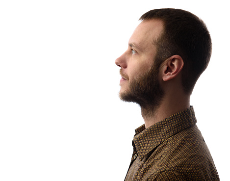 Side view of young bearded man isolated on gray background