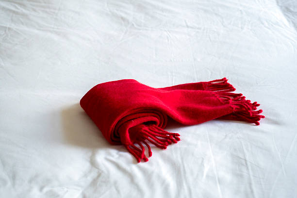 red woollen scarf on white bed