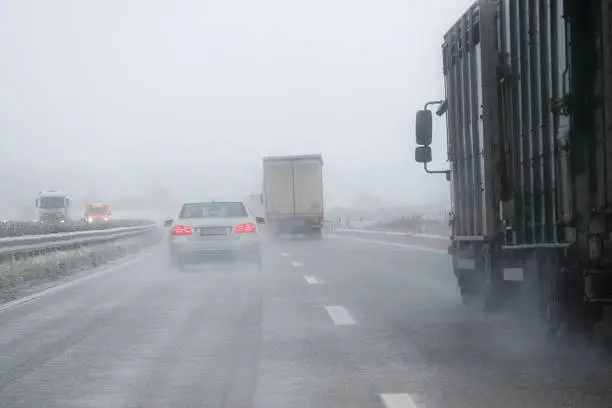 Photo of cars, trucks and rescue vehicle driving in dangerous winter weather