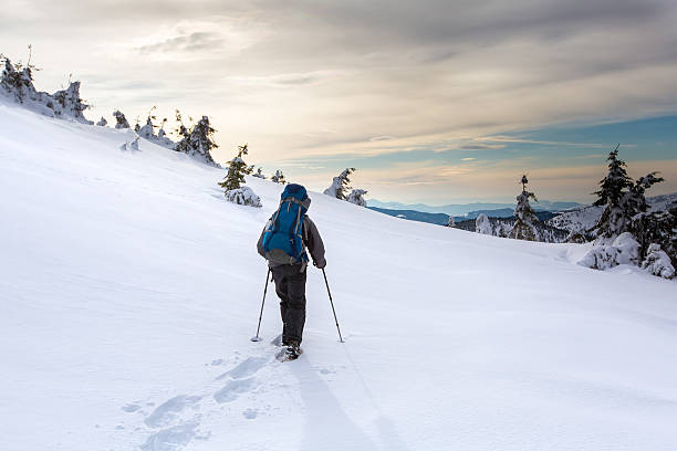 istock Man hiking in winter mountains before thunderstorm 627337924