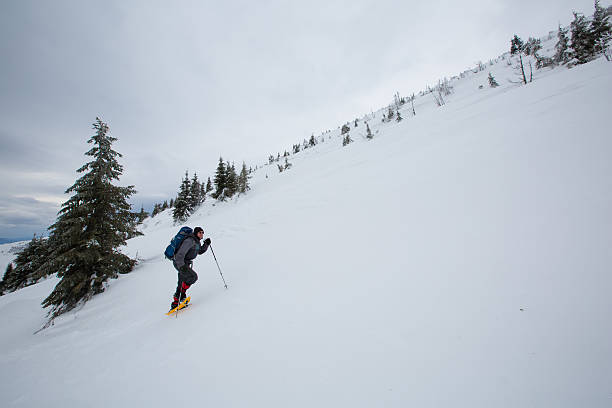 istock Man hiking in winter mountains before thunderstorm 627338344