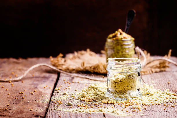 Mustard powder in a glass jar Mustard powder in a glass jar, vintage wooden background, selective focus dijonnaise stock pictures, royalty-free photos & images