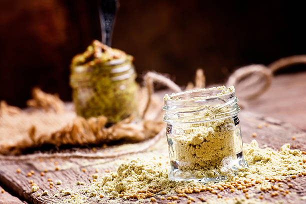 Mustard powder in a glass jar Mustard powder in a glass jar, vintage wooden background, selective focus dijonnaise stock pictures, royalty-free photos & images