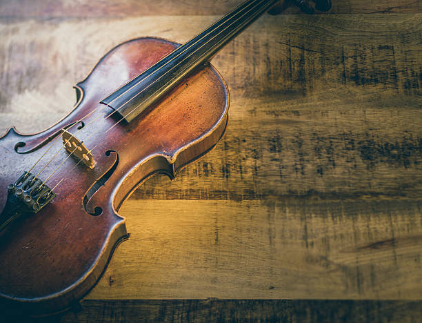 istock Old violin on a wooden background 627343514