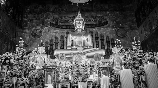 Buddha gold statue and thai art architecture in Wat Rakhang Khositaram  which is a public place In Bangkok ,Thailand. Black and white picture style.